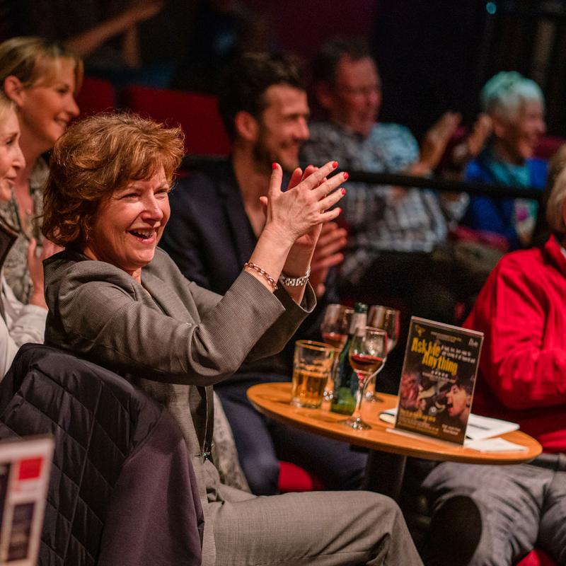 Group of people sitting at table applauding